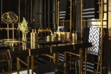 a bold art deco bathroom in black and gold, with marble, metal and lots of graphic touches here and there and gold accessories