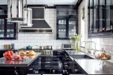 a bold art deco black and white kitchen with black cabinets with glass doors, a striped floor, glossy black cabinets and concrete countertops
