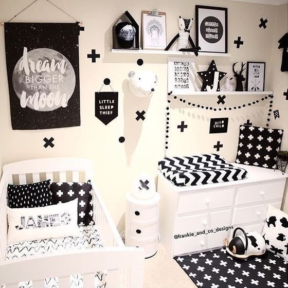 a bold monochromatic nursery with open shelving, a changing table and a crib plus lots of prints everywhere