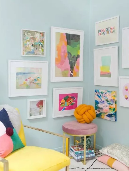 a bright and fun gallery wall taking two walls, with colorful abstract art and white frames