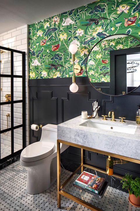 a bright eclectic bathroom with floral wallpaper, black panels, black and white tiles, a shower space and a sink on a chic metallic stand