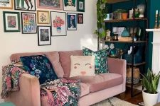 a bright free form gallery wall with mismatching frames and colorful artworks including floral ones plus textiles with the same patterns