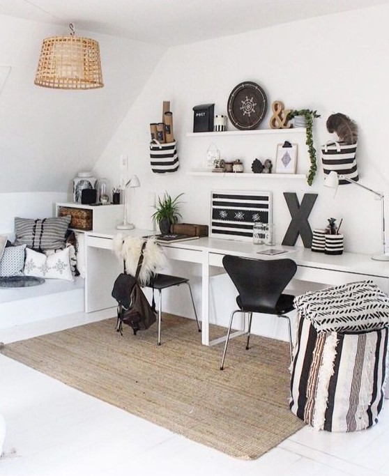 a chic attic Scandinavian home office with a shared desk, black chairs, a couple of shelves, artworks and objects on display
