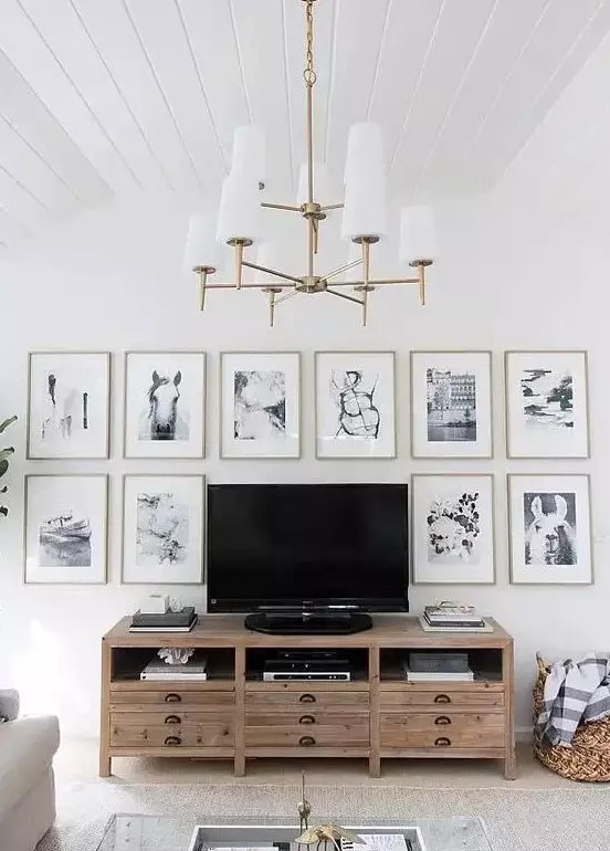 a chic gallery wall with thin gold frames, white matting and black and white photos framing the TV is cool