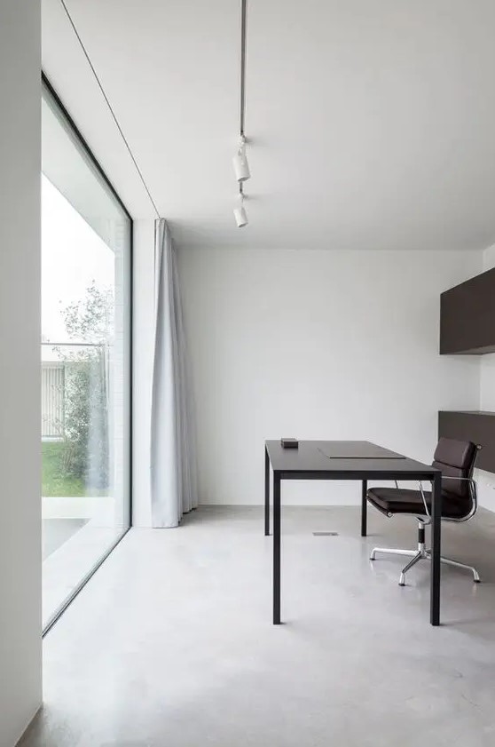 a clean minimalist home office with black storage units, a sleek black desk and a chair, a glazed wall for a lovely view