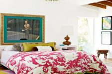 a colorful eclectic bedroom in a bright mix of colors, with bold artworks and a boho chandelier