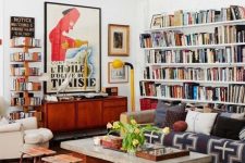 a colorful eclectic living room with open bookshelves, bright printed textiles, neutral furniture and touches of mid-century modern