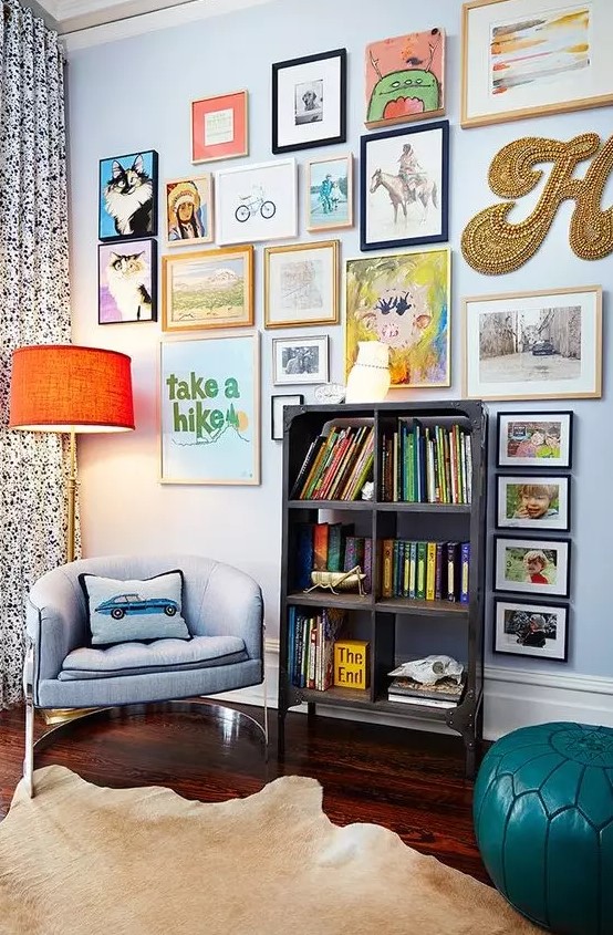a colorful gallery wlal with mismatching frames, a creative form, a gold bead monogram and some posters is fun