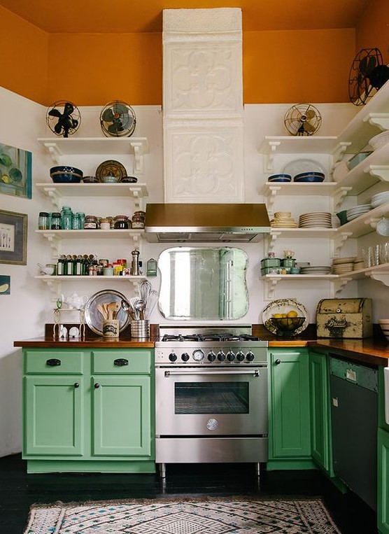a colorful vintage meets rustic kitchen with a tiled hood, a rust stripe, green cabinets and white shelves