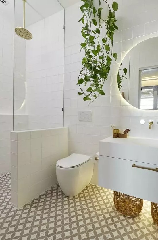 a contemporary bathroom clad with mosaic tiles, with a floating vanity, a half wall with glass to separate the shower space and a potted plant