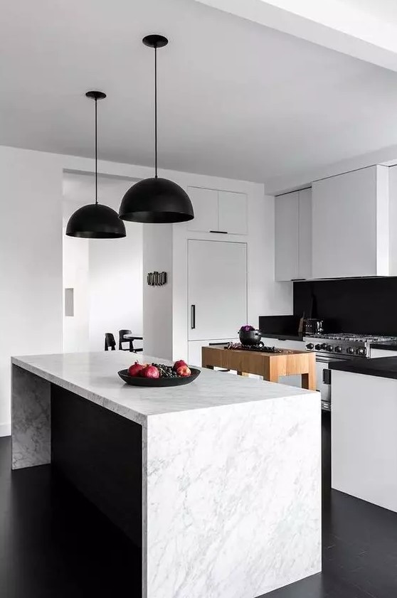 a contemporary black and white kitchen with sleek cabinets, black countertops and a backsplash, black pendant lamps