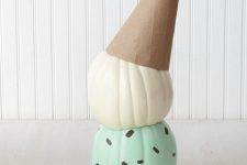 a couple of pumpkins attached to each other, painted and topped with a cardboard cone to show off a melting ice cream cone