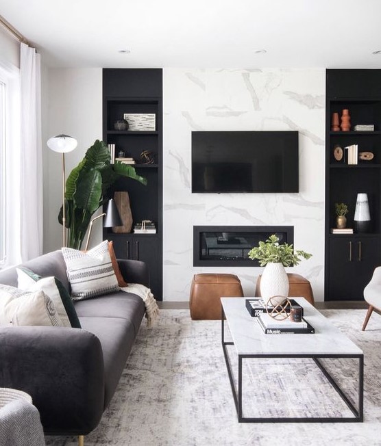 a cozy Scandinavian living room with a marble wall, a built in fireplace and chic furniture plus potted greenery