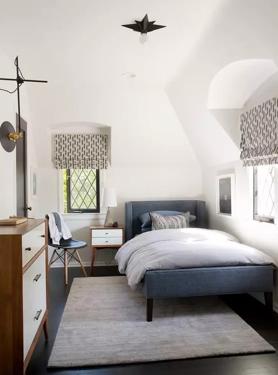 a cozy mid-century modern teen room with a blue upholstered bed, a dresser, printed textiles, a small nightstand and a chair