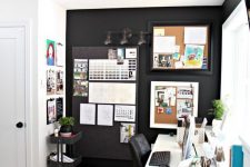 a cozy shared black and white home office with a black accent wall with memo boards and an IKEA Raskog cart, a white shared desk and black chairs