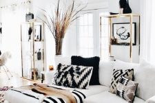 a fantastic black and white living room with stripes and chevrons, gilded touches for a glam feel and a dried herb arrangement