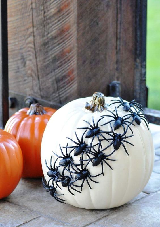 a faux white pumpkin decorated with black plastic spiders is a simple last minute craft for Halloween