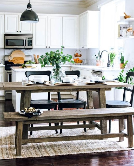 a fresh contemporary kitchen in white with a rustic dining zone with benches and touches of blakc for drama