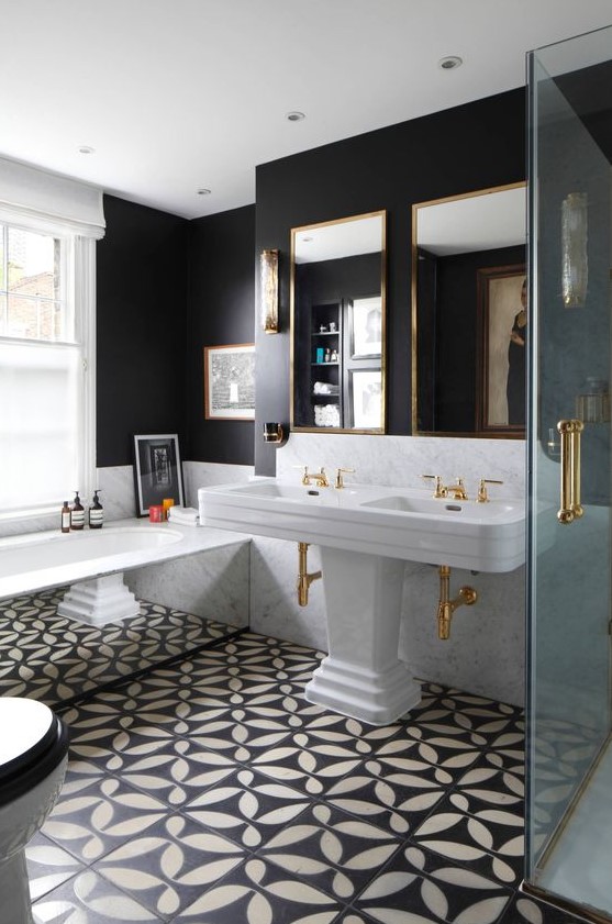a gorgeous art deco meets vintage bathroom in black and white, with a bath clad with mirrors and a large double sink