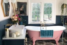 a lovely bathroom with a pink clawfoot bathtub