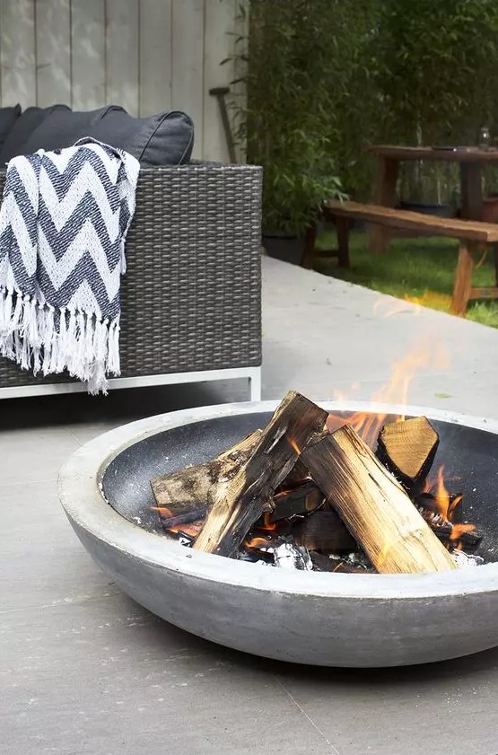 a large stone fire bowl is a perfect solution for a contemporary or minimalist outdoor space and it brings warmth to the spot