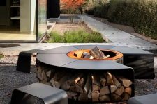a lovely contemporary fire pit with a bowl in the center surrounded with a table and firewood storage plus matching blackened steel stools