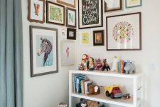 a lovely corner gallery wall in a kids’ room with pretty monograms, posters and faux taxidermy plus arrows on top is wow
