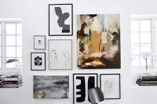 a lovely modern gallery wall with a non-framed central artwork and thin framed other works is chic