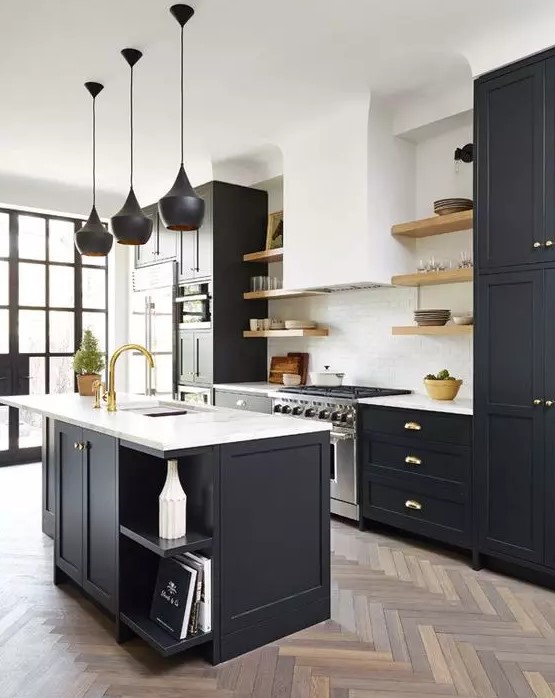 a lovely modern kitchen with black shaker cabinets and a kitchen island, white stone countertops, a white subway tile backsplash, black pendant lamps