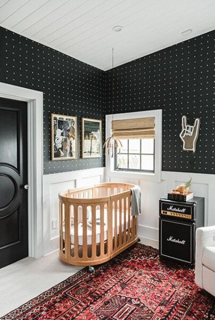a mid-century moden nursery with polka dot walls, a stained crib, a printed rug, artwork and a nightstand and some decor
