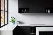 a minimalist black and white kitchen with matte black cabinets, white stone countertops and a backsplash, black stools is a chic space to be