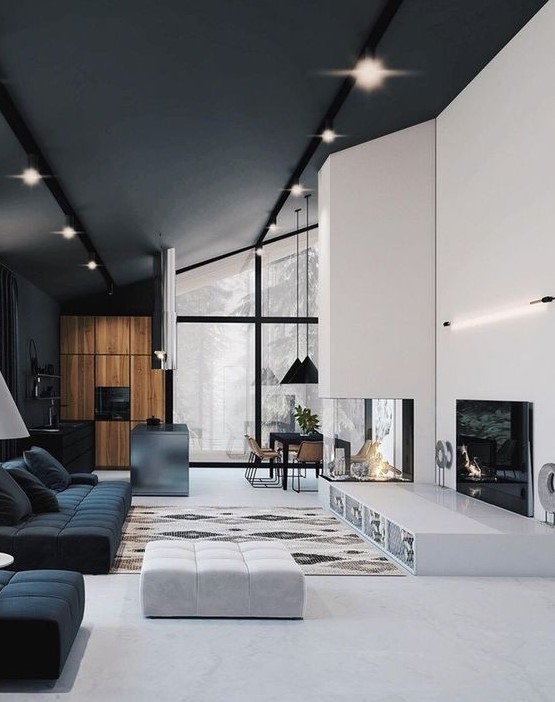a minimalist living room with a built-in fireplace, a sleek platform, black and white furniture and simple lights