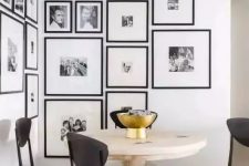 a modern and elegant free form gallery wall covering a whole corner and with matching black frames and white mats is wow