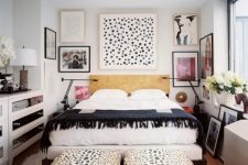 a monochromatic eclectic bedroom with a dashing gallery wall, two animal printed ottomans and mirrored dressers