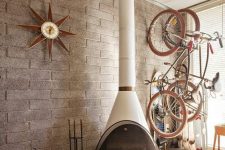 a neutral space with a white Malm fireplace, a magazine stand and a couple of bikes stored on the wall