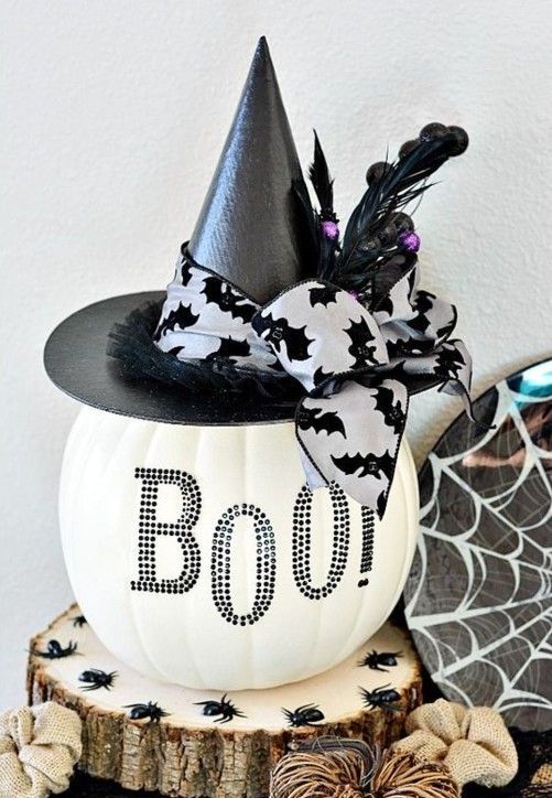 a plastic white pumpkin decorated with black sequins and a black witch hat with berries and ribbon for Halloween decor