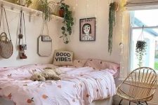 a pretty teen room with a storage bed, a shelf with lots of potted plants and lights hanging over the bed, pretty bedding and art