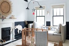 a refined black and white nursery with a neutral rug, sofa and a woodne crib plus baskets