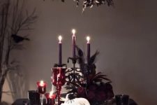 a refined deep burgundy and black Halloween tablescape with purple candles, burgundy candleholders, skulls, crows and black linens is great for a party