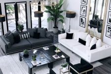 a sophisticated black and white living room with black and white sofas, black and striped pillows, four black coffee tables and a large mirror in a chic frame