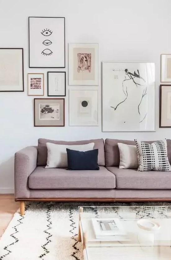 a sophisticated gallery wall with mismatching frames and mismatching artworks covering the wall horizontally is super stylish