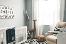 a stylish black and white nursery with a neutral leather chair and an ottoman to add warming touches