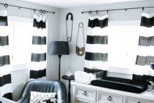a stylish nursery with a vintage dresser, striped curtains, printed bedding and a faux fur rug