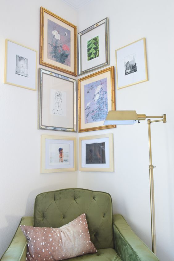 a stylish reading nook with a green chair and a polka dot pillow, a corner gallery wall with various frames and catchy artwork