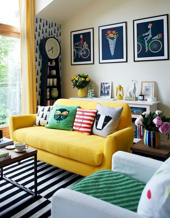 a super colorful eclectic living space with a grid gallery wall, a yellow sofa, lots of prints and a contemporary coffee table