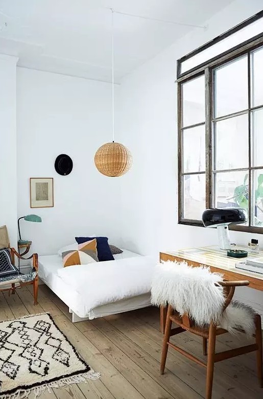 a teen Scandinavian room with a small bed, a desk and a chair, a rattan pendant lamp and a large window with no curtains