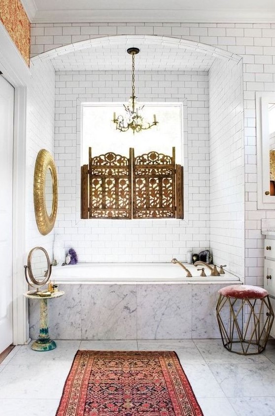 a unique eclectic bathroom with touches of vintage and Moroccan styles, with gilded elements in both styles and a boho rug