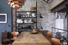 a vintage industrial dining space with a large metal and wood dining table, plywood chairs and stools, metal lamps and a pendant one