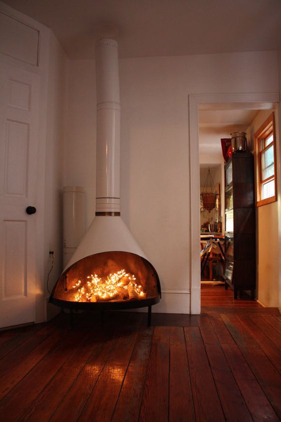 a white Malm fireplace with firewood and LED lights inside is a lovely decor idea for an awkward nook