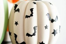 a white faux pumpkin decorated with black bats and stars looks very nice and won’t be difficult to DIY